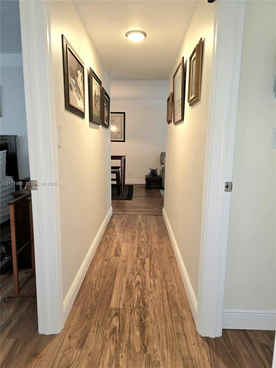 5387 SW 40th Avenue, #203, Dania Beach, FL 33314 Hallway featuring wood-finish flooring and a flush-mount ceiling light fixture