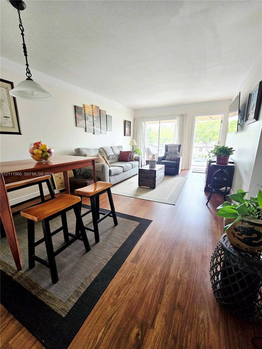 5387 SW 40th Avenue, #203, Dania Beach, FL 33314 Wood-finish flooring throughout, sliding glass patio door, and pendant lighting fixture
