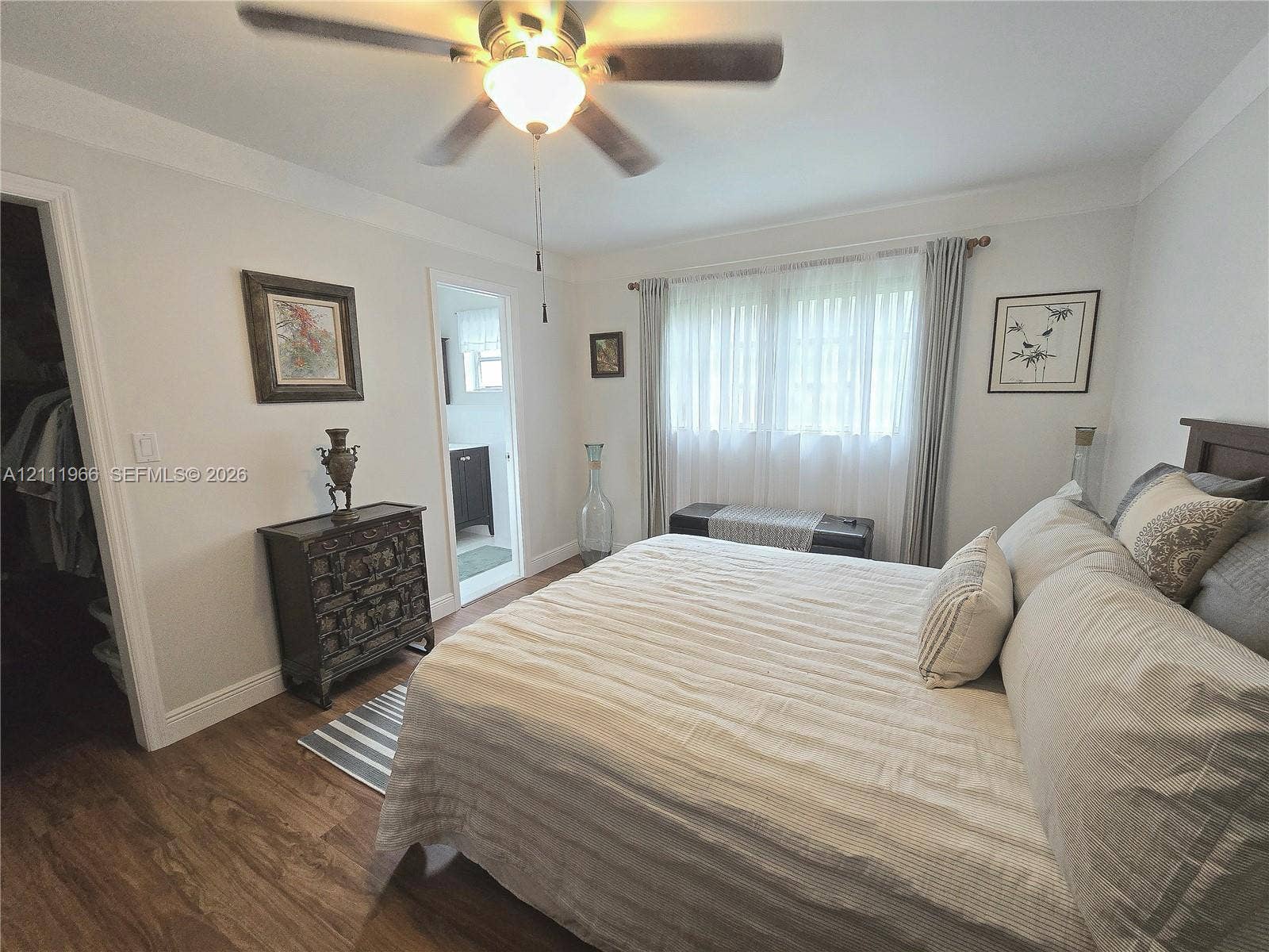 5387 SW 40th Avenue, #203, Dania Beach, FL 33314 Room featuring wood-finish flooring, a ceiling fan with integrated light fixture, crown molding, and a walk-in closet