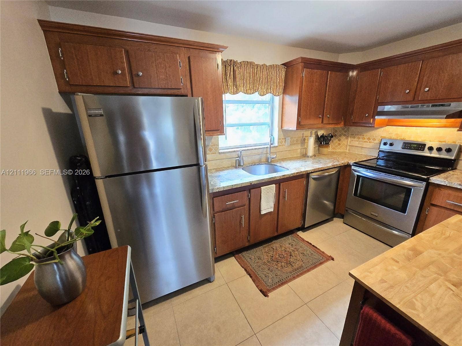 5387 SW 40th Avenue, #203, Dania Beach, FL 33314 Kitchen featuring wood cabinetry, stainless steel appliances, tile flooring, and a single-basin sink