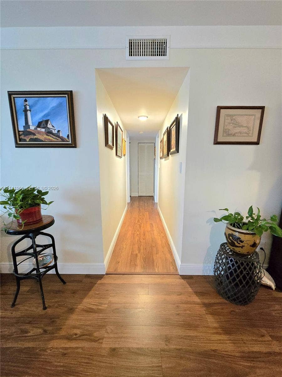 5387 SW 40th Avenue, #203, Dania Beach, FL 33314 Interior hallway featuring wood-finish flooring and bi-fold closet doors