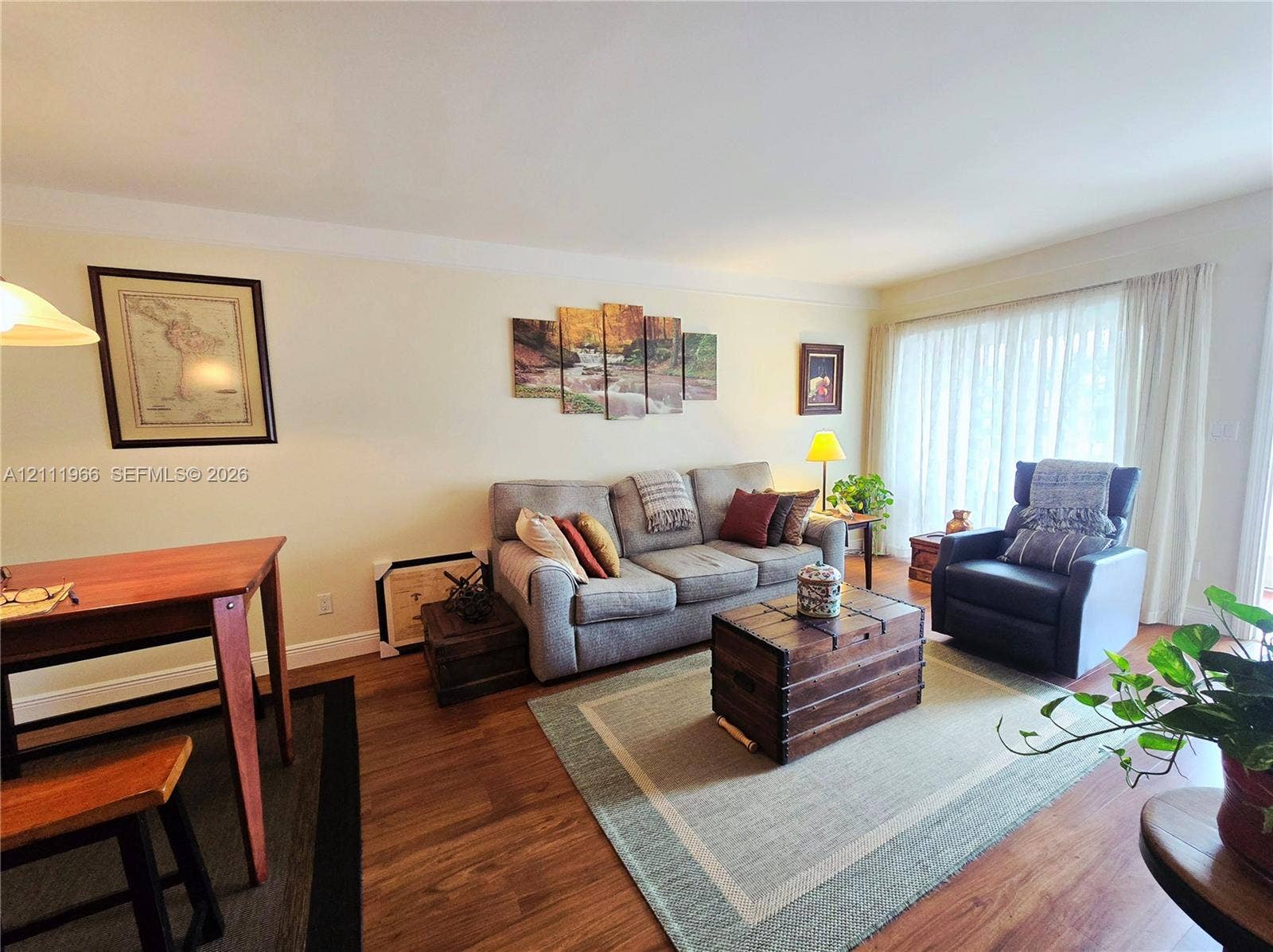 5387 SW 40th Avenue, #203, Dania Beach, FL 33314 Living area featuring wood-finish flooring and floor-to-ceiling window drapery