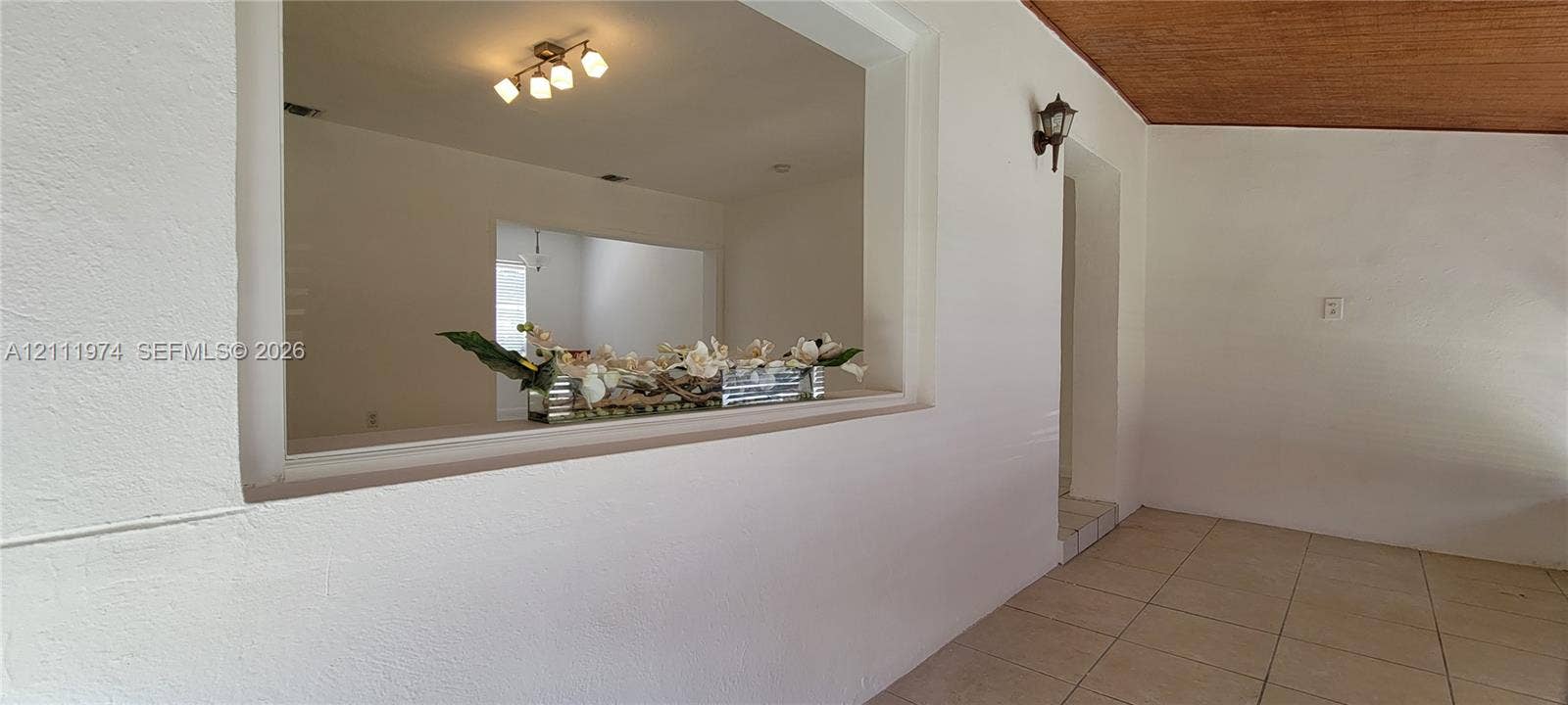 600 SW 44th Court, Miami, Miami, FL 33134 Interior space featuring a pass-through opening, ceramic tile flooring, a wood-plank ceiling, and an attached wall-mounted lantern-style light fixture