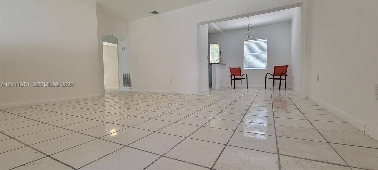 600 SW 44th Court, Miami, Miami, FL 33134 Interior space featuring white tile flooring, neutral wall paint, and an overhead pendant light fixture