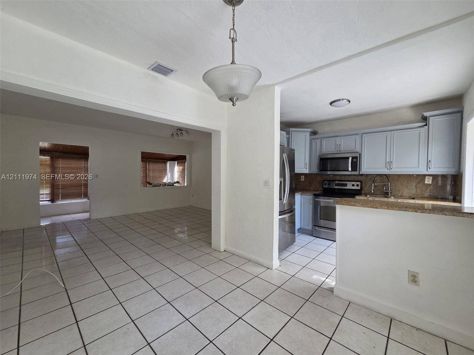 600 SW 44th Court, Miami, Miami, FL 33134 Kitchen featuring shaker-style cabinetry, stone countertops, stainless steel appliances, ceramic tile flooring, and a pendant light fixture