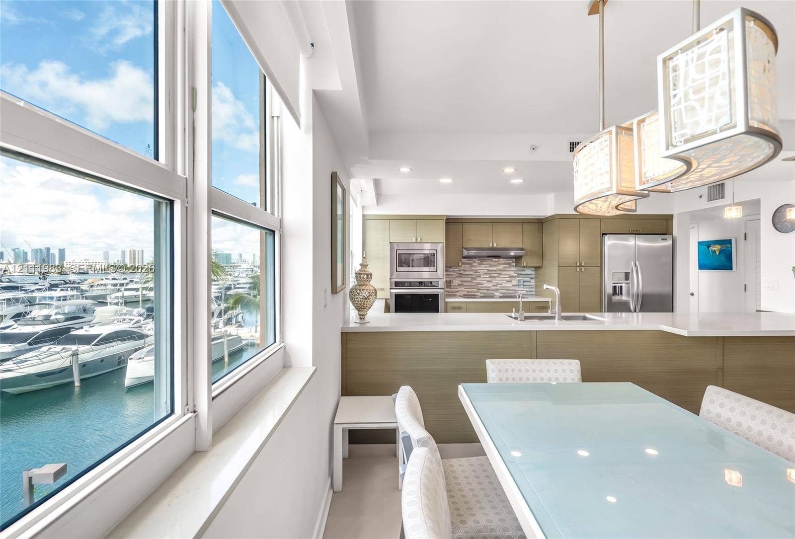 90 Alton Road, #TH-8, Miami Beach, FL 33139 Kitchen featuring flat-panel cabinetry, quartz countertops, stainless steel appliances, multi-toned tile backsplash, and oversized glass pendant lighting