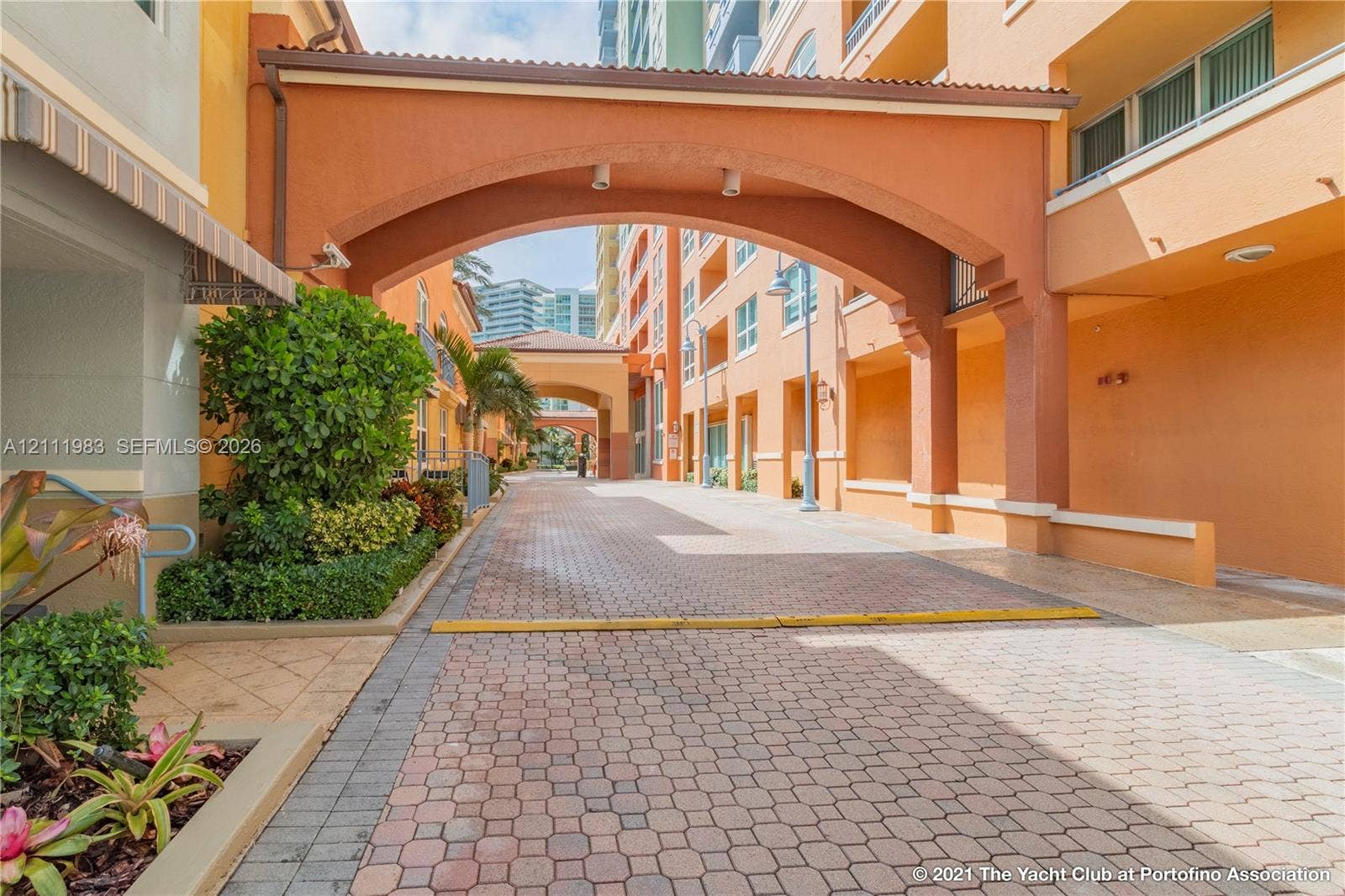 90 Alton Road, #TH-8, Miami Beach, FL 33139 Paver-stone motor court featuring architectural archways, stucco exterior walls, and manicured perimeter landscaping