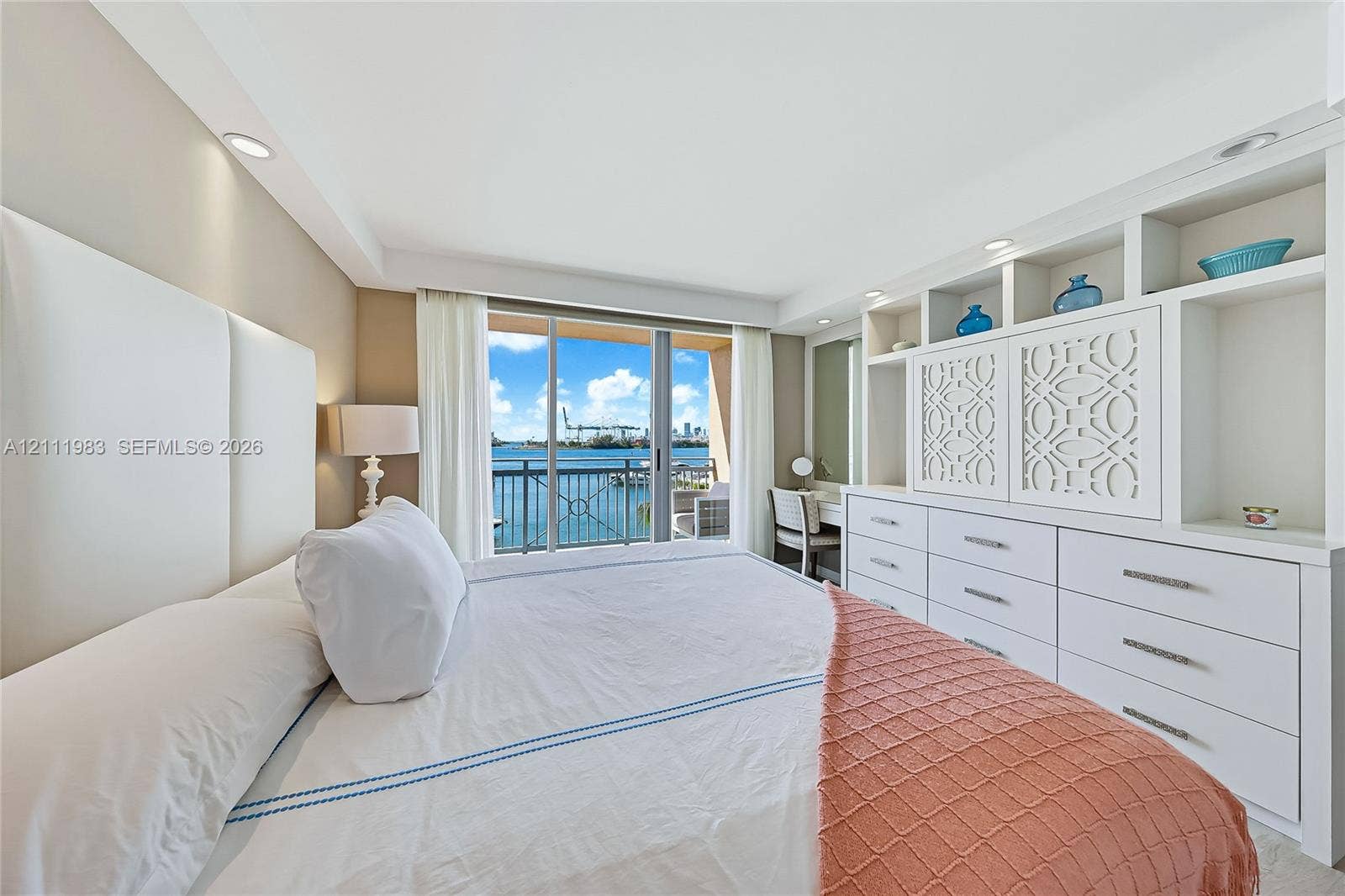 90 Alton Road, #TH-8, Miami Beach, FL 33139 Built-in wall-to-wall cabinetry with integrated open shelving and drawers, floor-to-ceiling glass sliding doors, recessed lighting, and water scenery