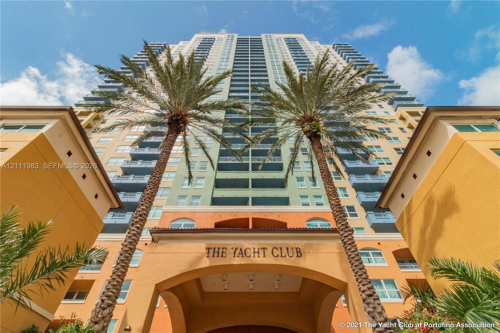 90 Alton Road, #TH-8, Miami Beach, FL 33139 High-rise residential exterior featuring multi-story architectural design, private recessed balconies, arched entryway, and mature palm landscaping