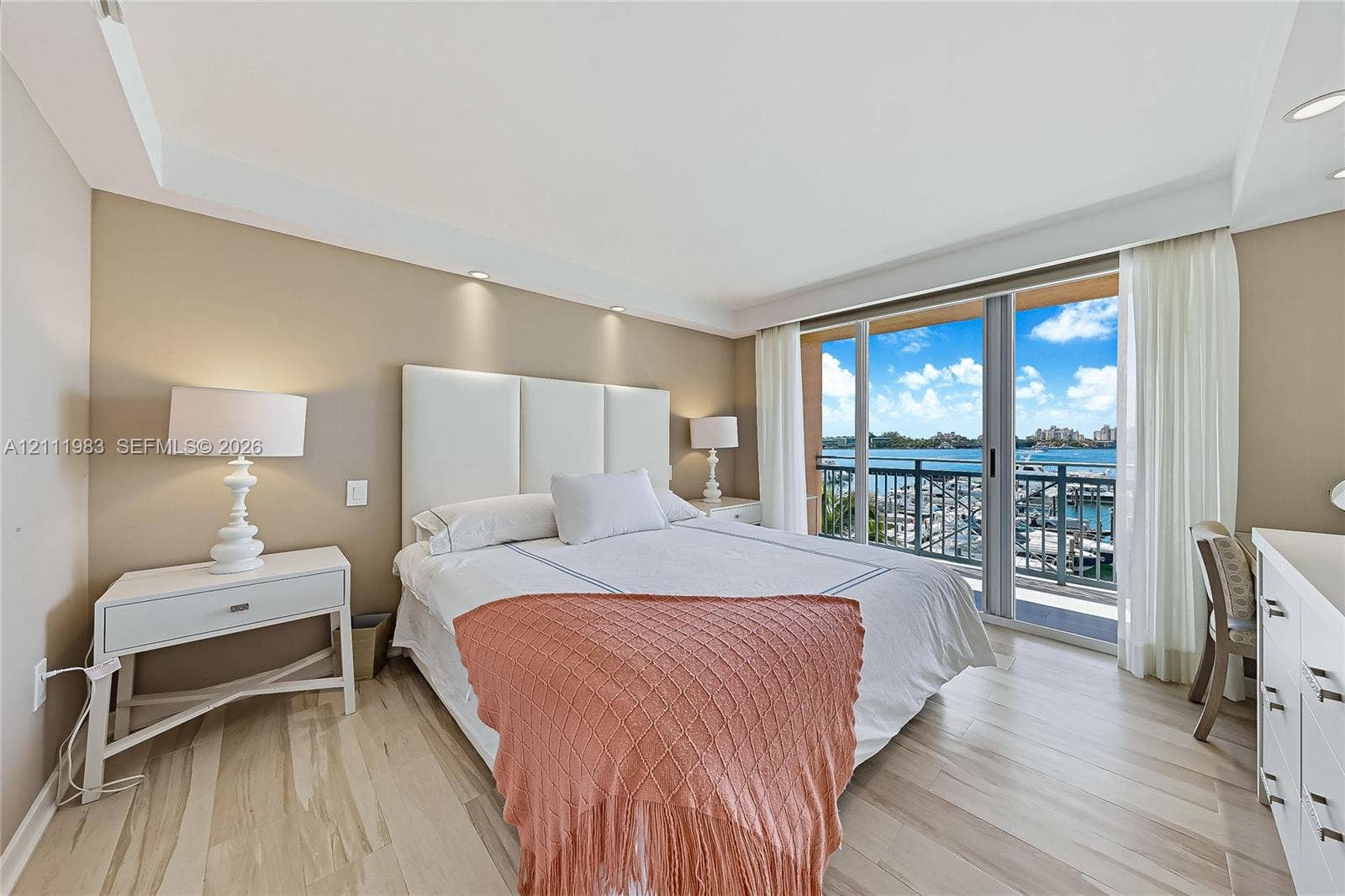 90 Alton Road, #TH-8, Miami Beach, FL 33139 Wood-finish flooring, recessed ceiling lighting, and sliding glass doors opening to a balcony with water and marina scenery