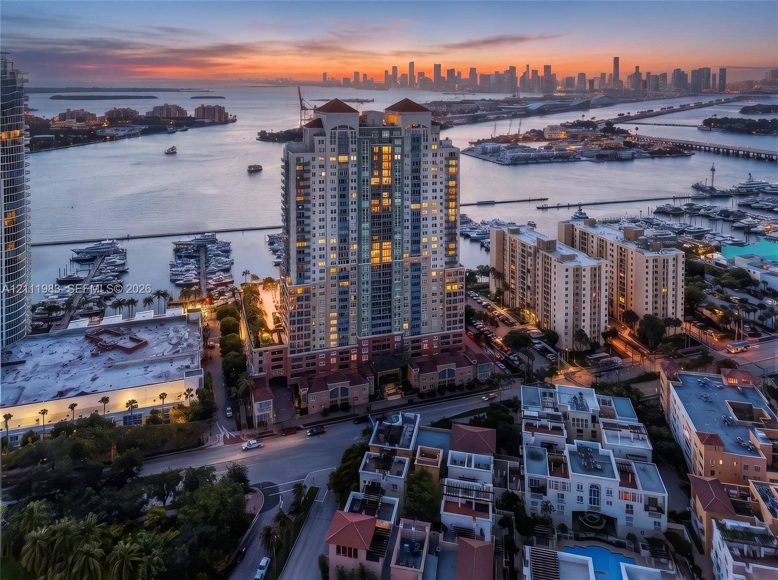 90 Alton Road, #TH-8, Miami Beach, FL 33139 Aerial perspective of a high-rise residential tower featuring a multi-story masonry facade, terracotta-tiled roof accents, private balcony tiers, and a waterfront location