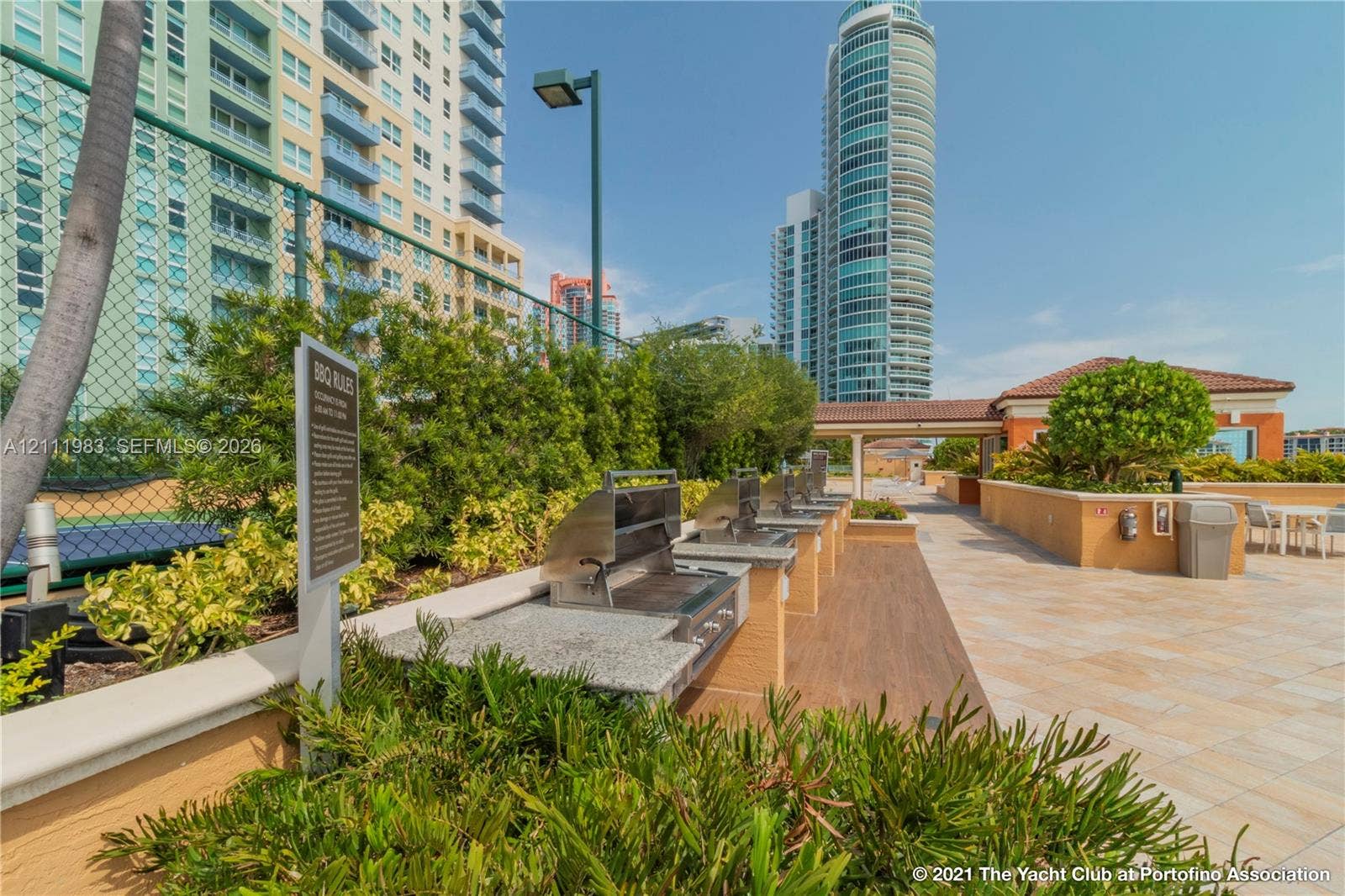 90 Alton Road, #TH-8, Miami Beach, FL 33139 Outdoor grilling area featuring stainless steel built-in barbecue grills, stone-finish countertops, tile flooring, and mature landscaping