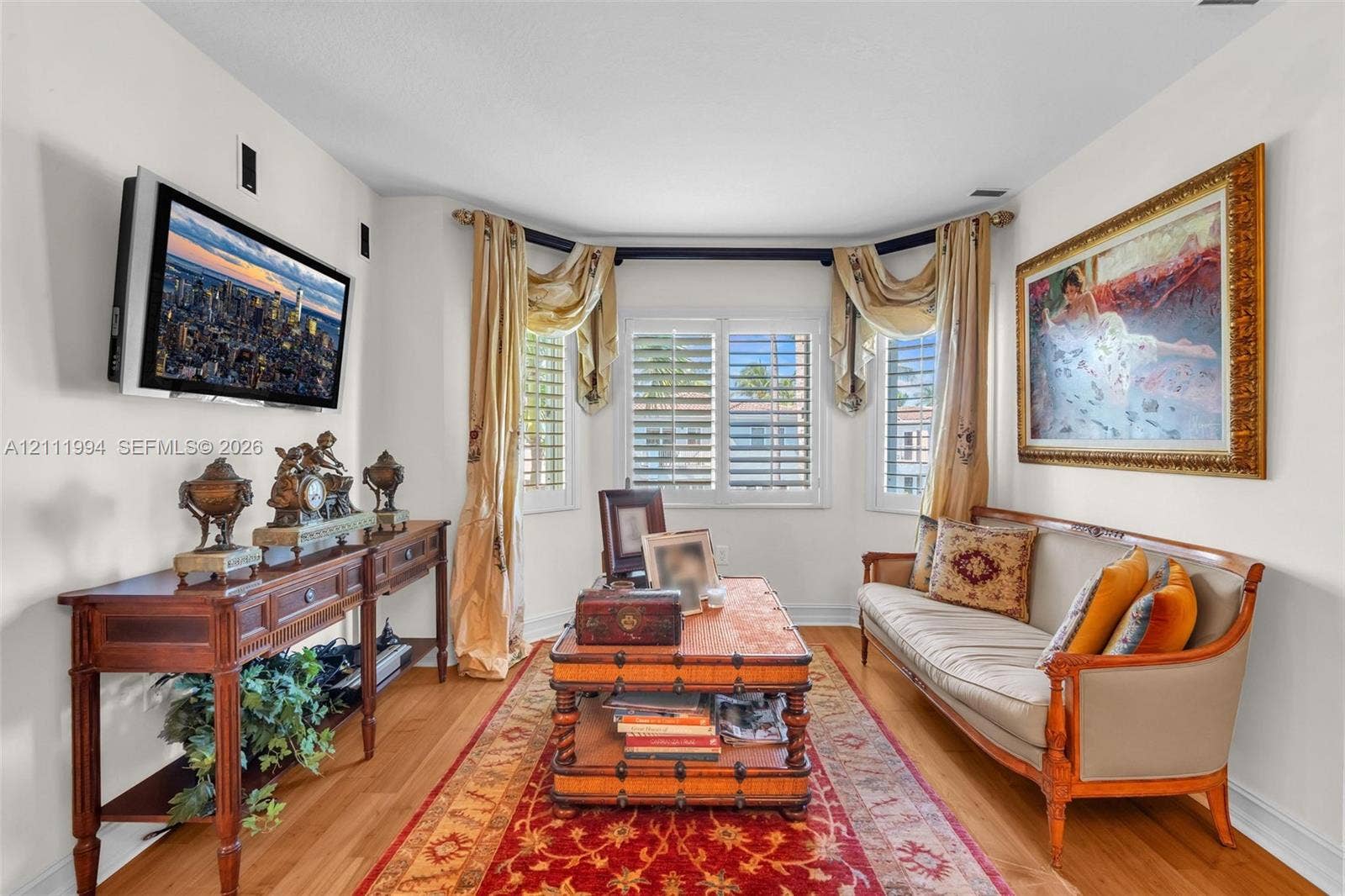 Bay window with plantation shutters and wood-finish flooring