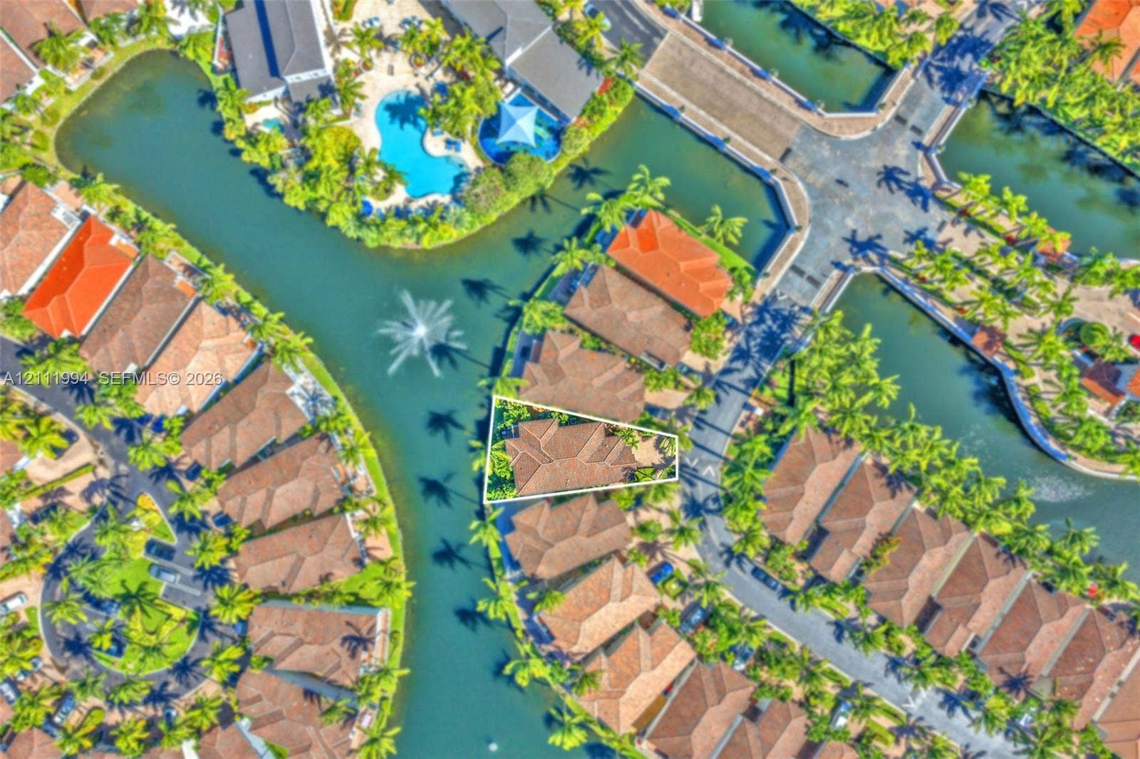 Aerial perspective of a property featuring a tiled roof and water frontage with direct canal access