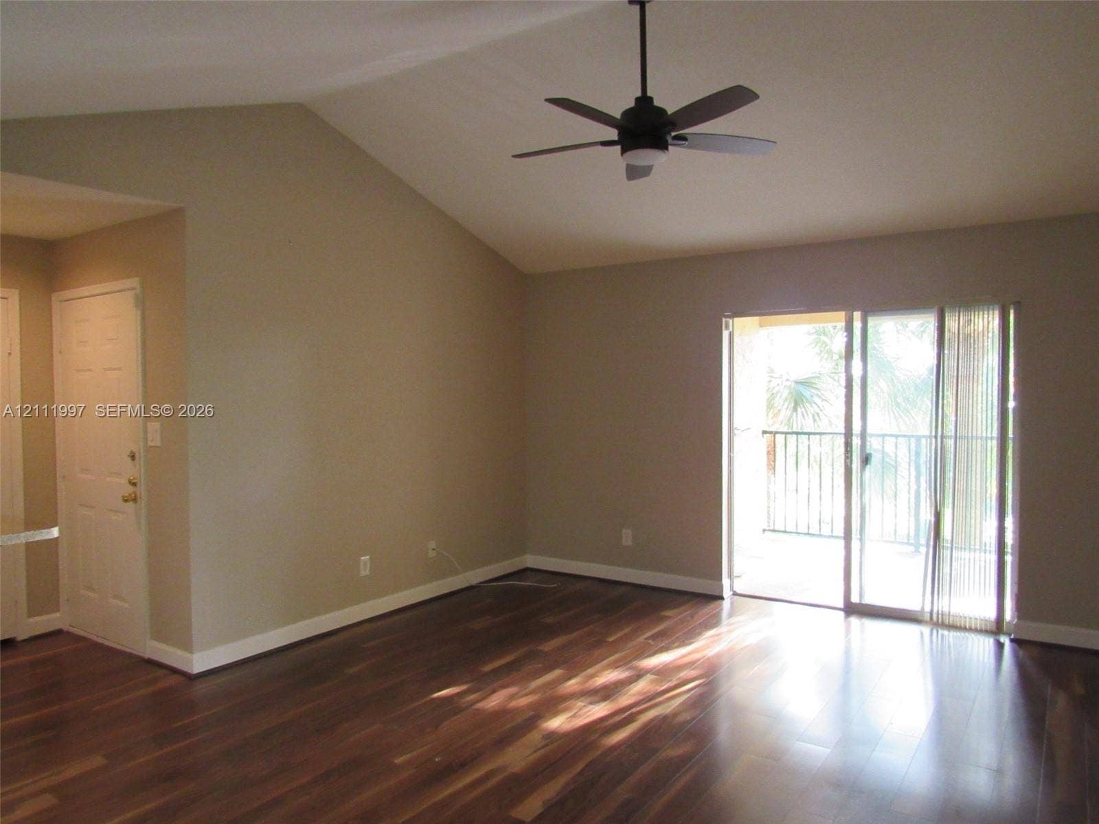 733 Riverside Drive, #1232, Coral Springs, Coral Springs, FL 33071 Interior space featuring vaulted ceilings, wood-finish flooring, a ceiling fan, and sliding glass doors with access to an exterior balcony