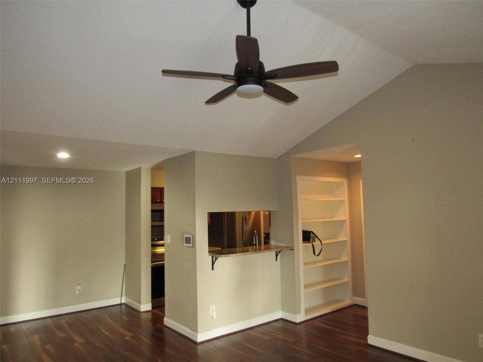 733 Riverside Drive, #1232, Coral Springs, Coral Springs, FL 33071 Vaulted ceilings, wood-finish flooring, built-in shelving, and a pass-through opening with stone-surface counter