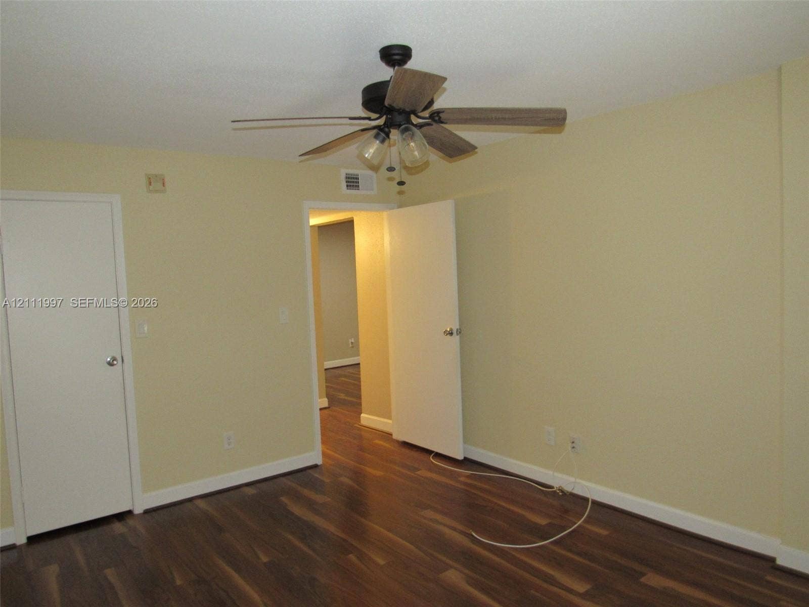 733 Riverside Drive, #1232, Coral Springs, Coral Springs, FL 33071 Room featuring wood-finish flooring, a ceiling fan with multi-light fixture, and two interior doors