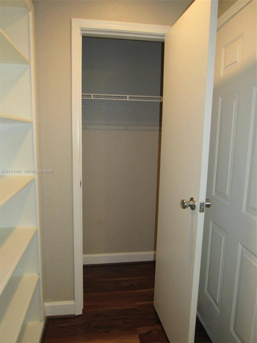 733 Riverside Drive, #1232, Coral Springs, Coral Springs, FL 33071 Built-in white shelving unit, wood-finish flooring, and closet featuring a wire hanging rack