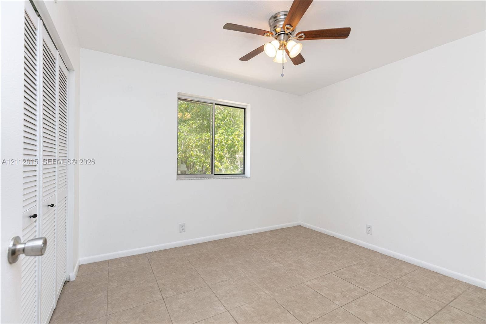 717 Gardens Drive, #201, Pompano Beach, Pompano Beach, FL 33069 Room featuring tile flooring, ceiling fan with integrated lighting, window, and bifold closet doors