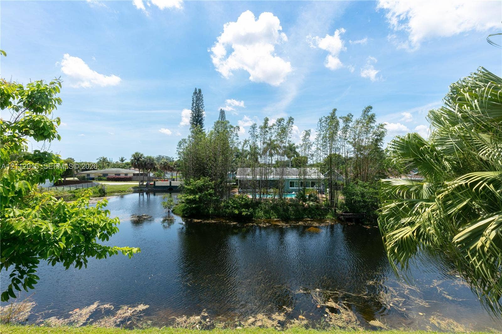 717 Gardens Drive, #201, Pompano Beach, Pompano Beach, FL 33069 Waterfront property featuring a private pond, mature trees, and established landscaping