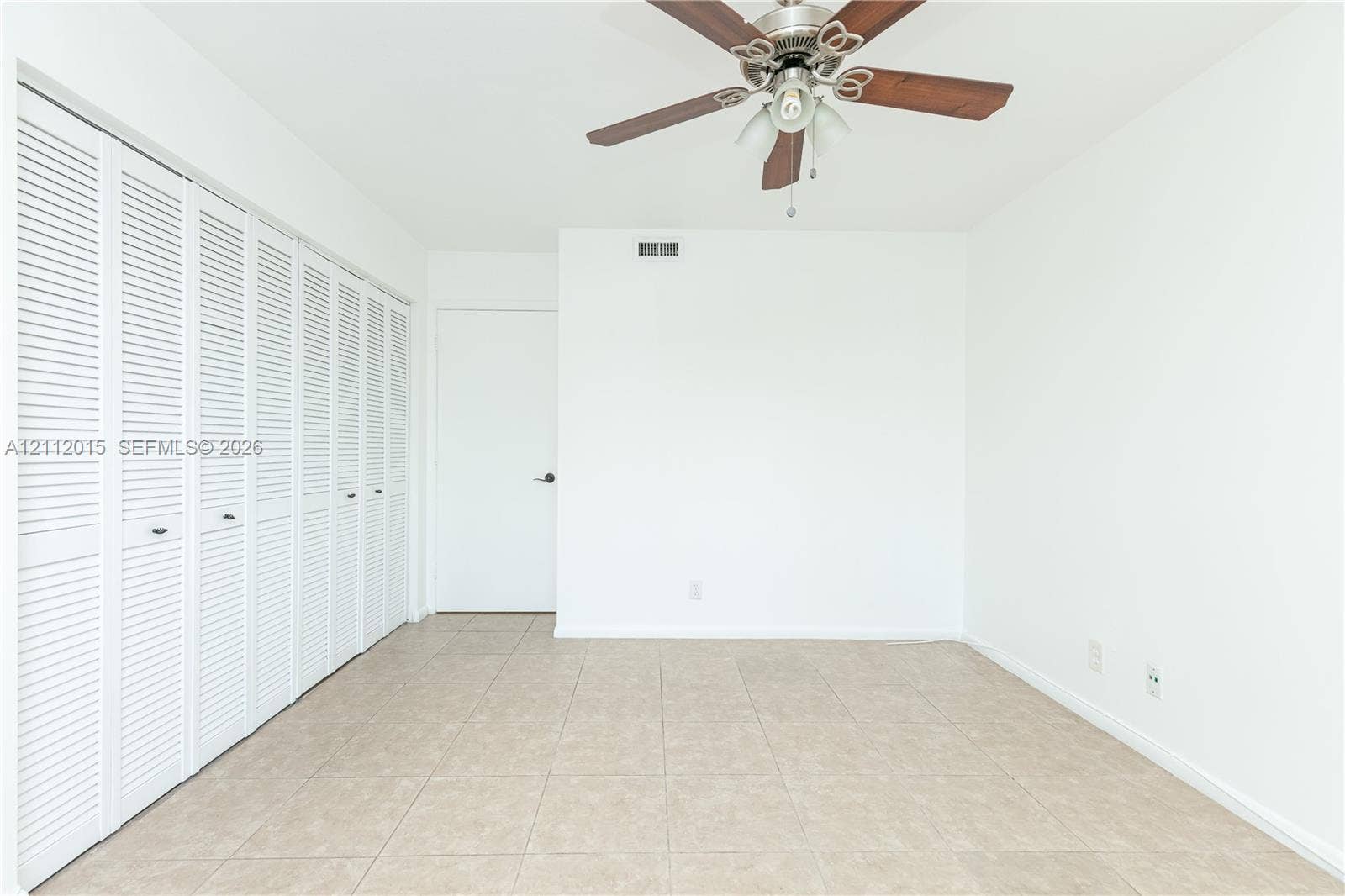 717 Gardens Drive, #201, Pompano Beach, Pompano Beach, FL 33069 Neutral-toned ceramic tile flooring, multi-panel louvered closet doors, and a ceiling-mounted fan with integrated lighting