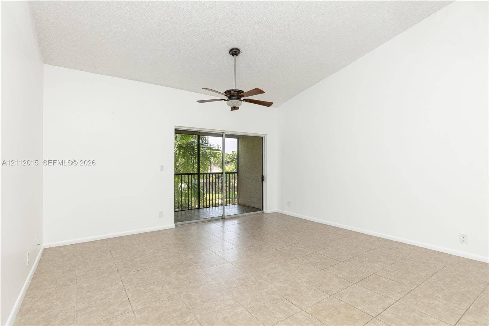 717 Gardens Drive, #201, Pompano Beach, Pompano Beach, FL 33069 Room featuring vaulted ceilings, tile flooring, a central ceiling fan, and sliding glass doors with access to a railed balcony