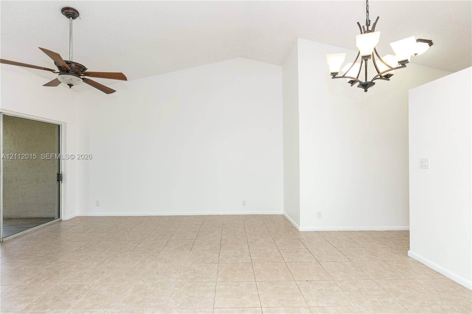 717 Gardens Drive, #201, Pompano Beach, Pompano Beach, FL 33069 Vaulted ceiling, ceramic tile flooring, multi-arm metal chandelier, ceiling fan with wood-finish blades, and sliding glass door