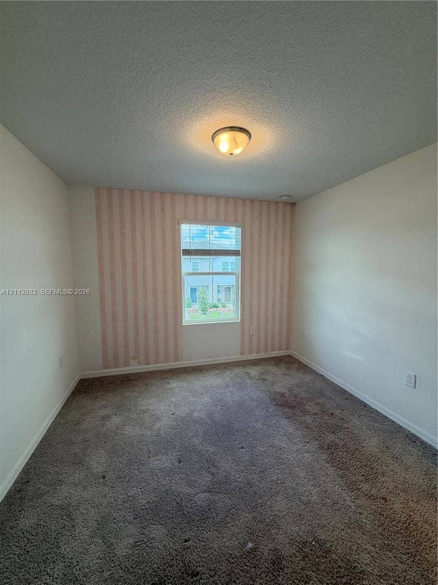 254 Mandovis Street, Davenport, Davenport, FL 33837 Room featuring carpeting, a single window with horizontal blinds, and a decorative striped accent wall