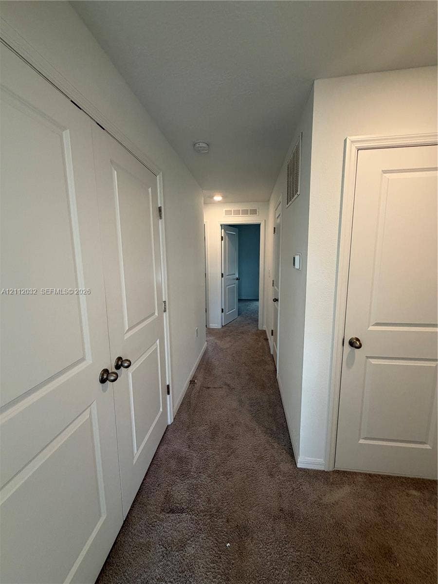 254 Mandovis Street, Davenport, Davenport, FL 33837 Hallway featuring neutral-toned carpeting, multi-panel doors with round hardware, and recessed lighting