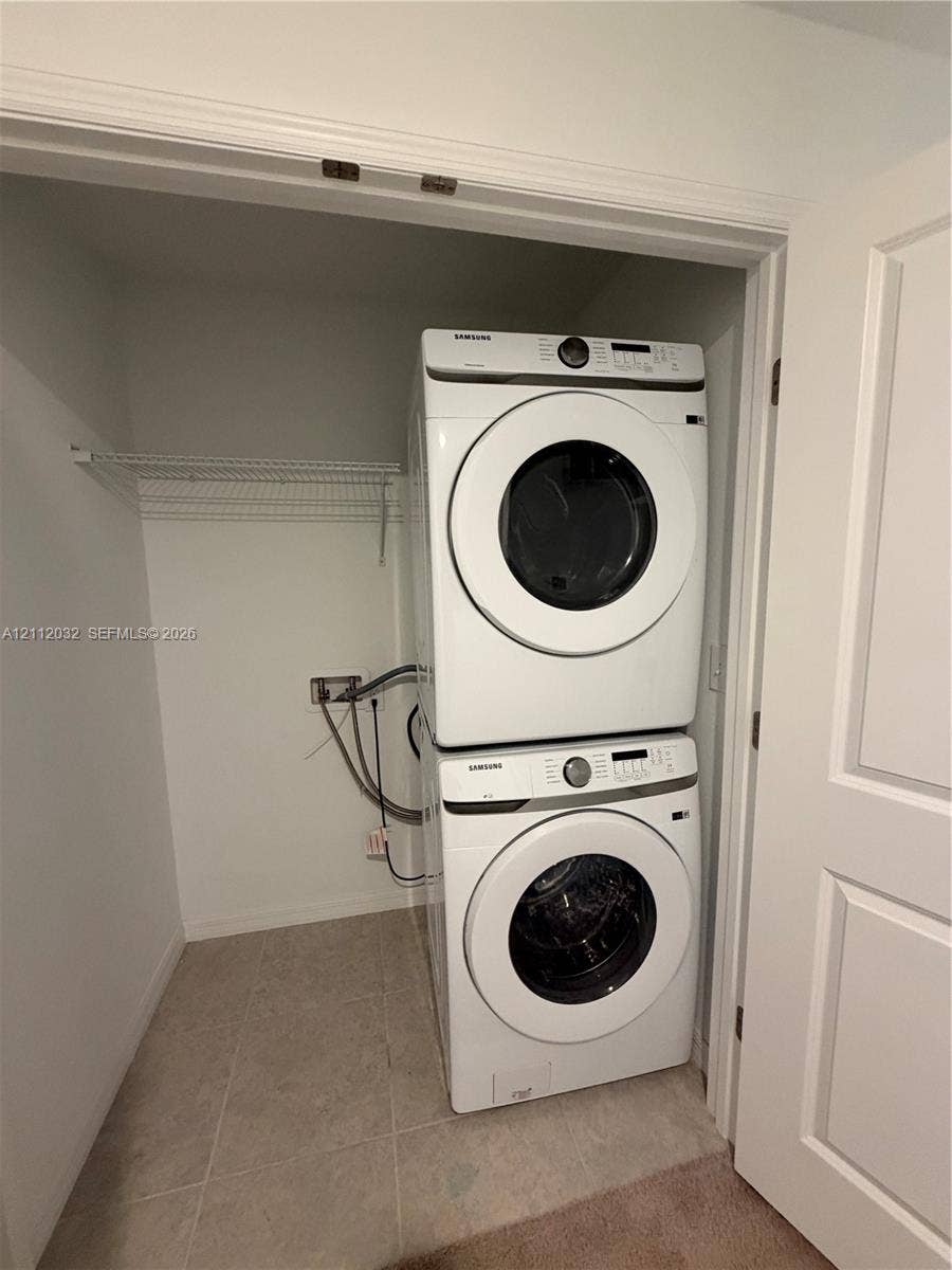 254 Mandovis Street, Davenport, Davenport, FL 33837 Stacked laundry appliances with wire shelving in a dedicated enclosure