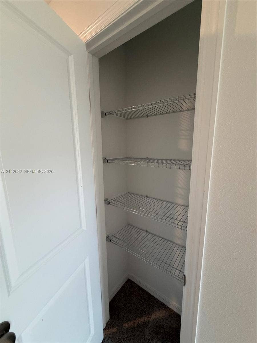 254 Mandovis Street, Davenport, Davenport, FL 33837 Built-in storage closet featuring four tiered wire shelves and a solid-core hinged door