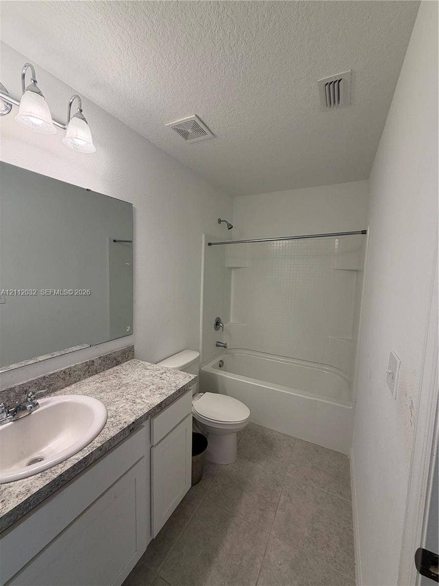 254 Mandovis Street, Davenport, Davenport, FL 33837 Bathroom featuring a vanity with a stone-finish countertop, integrated sink, and oversized mirror