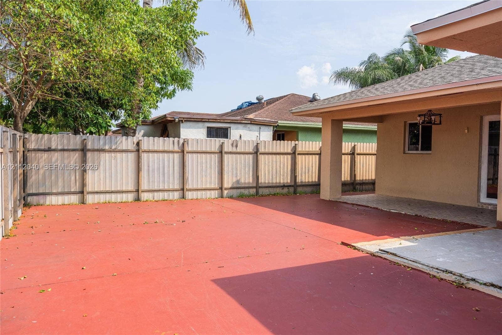Backyard featuring a paved patio, a covered porch, and a full-height perimeter fence
