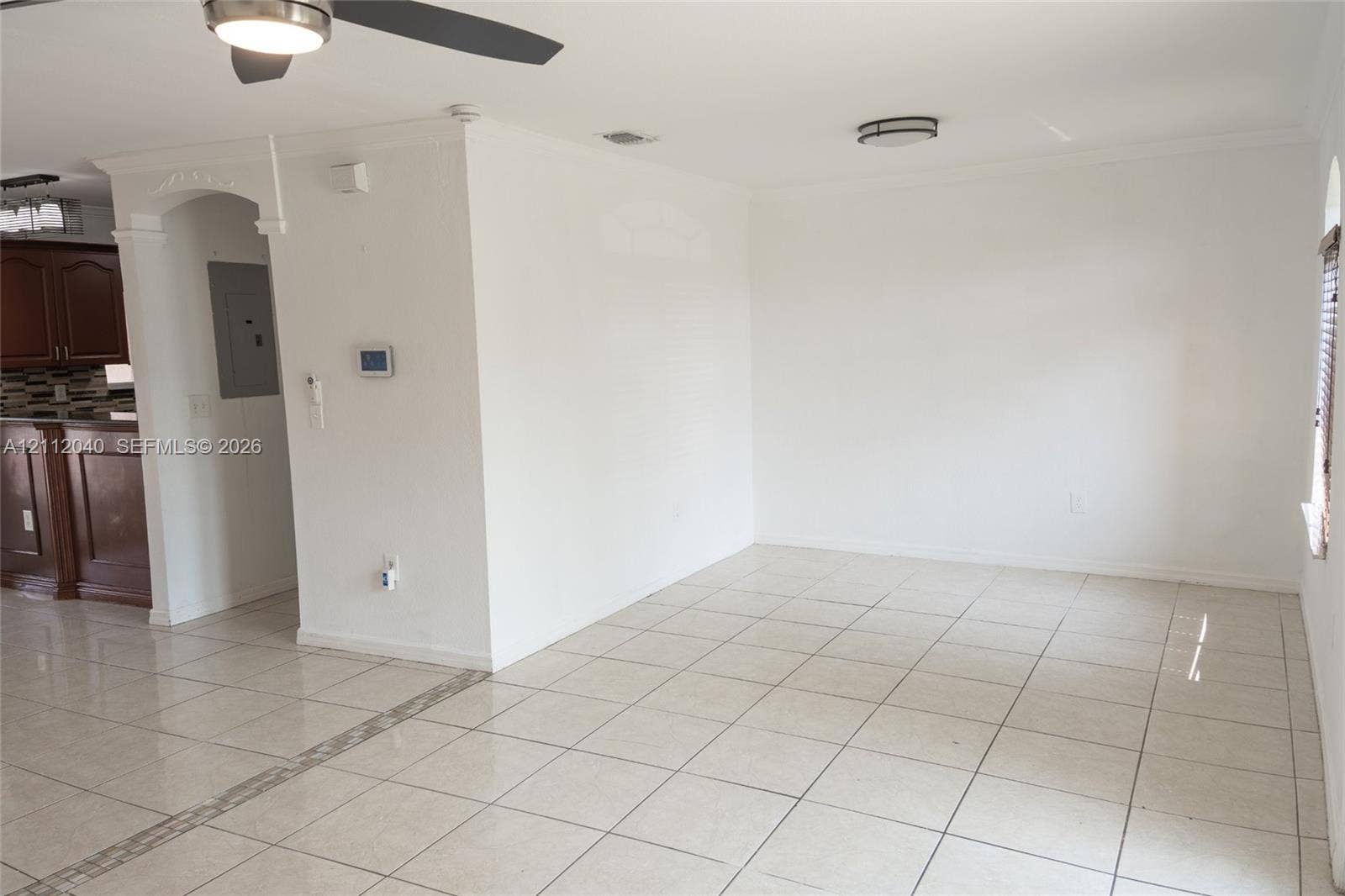 Neutral-toned tile flooring, ceiling fan, and flush-mount lighting