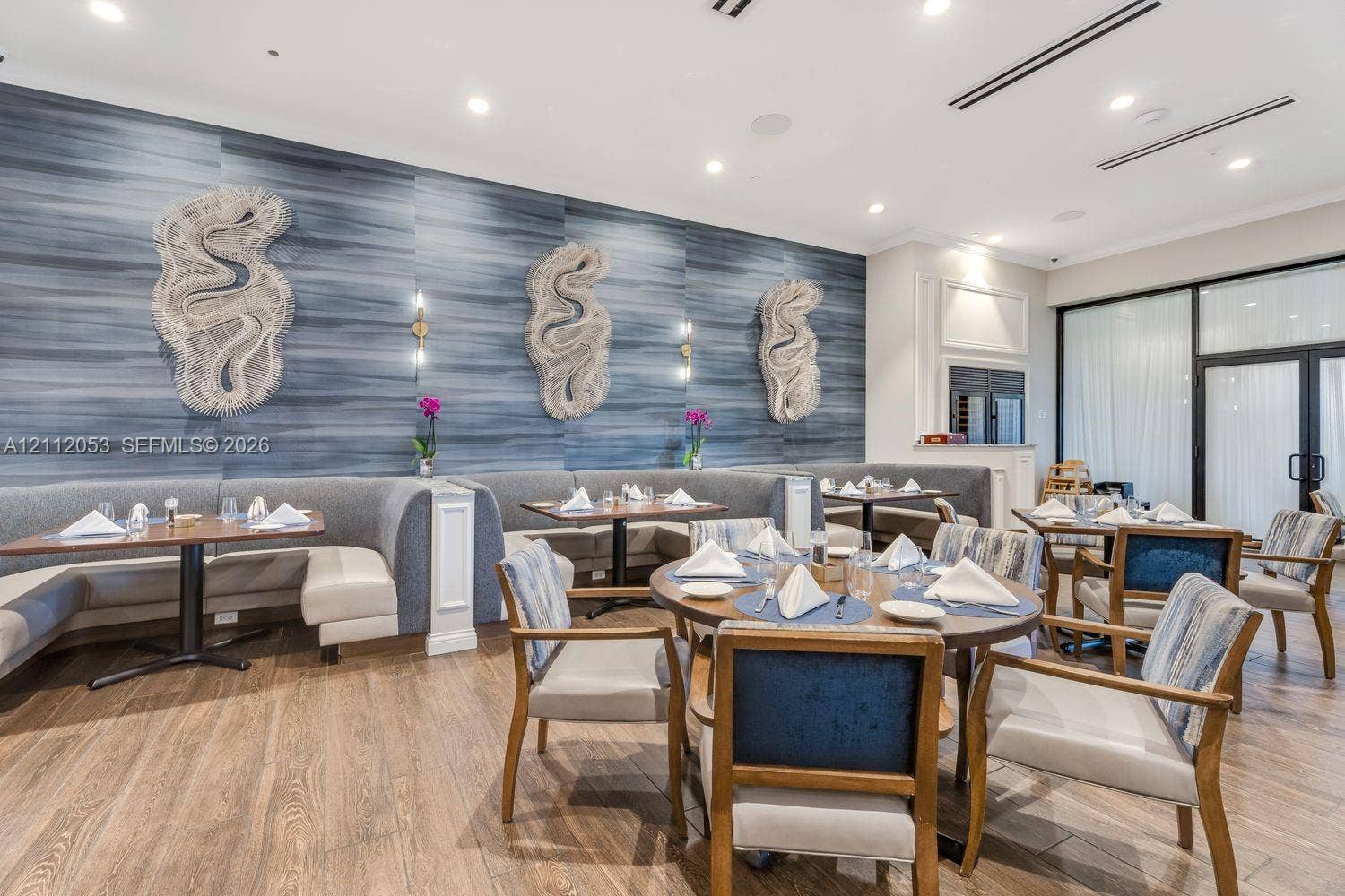 Textured blue accent wall featuring decorative wall sculptures, recessed lighting, and wood-finish flooring