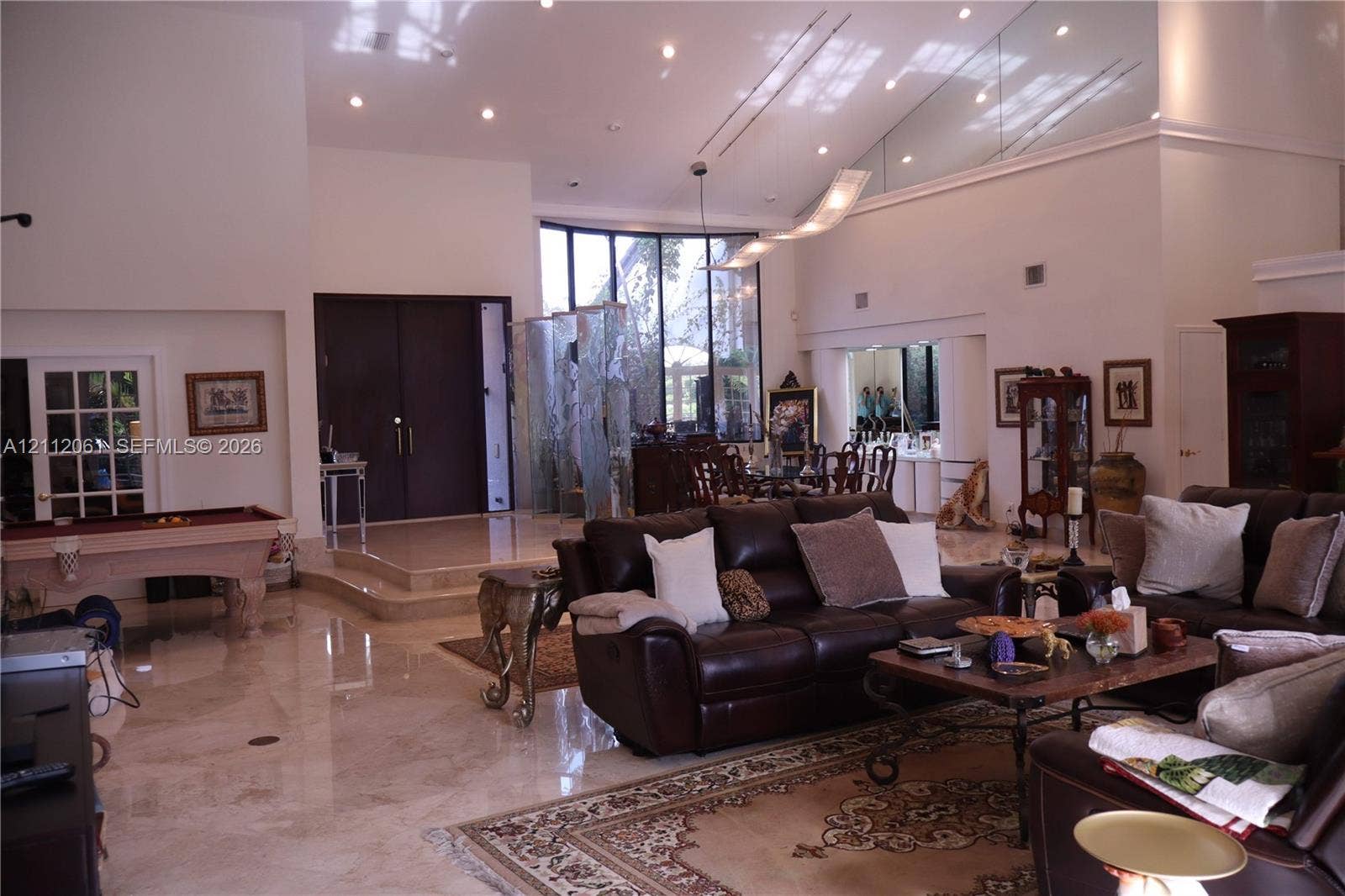 17191 SW Shaddock Lane, Boca Raton, FL 33487 Vaulted ceilings with recessed lighting, polished stone flooring, floor-to-ceiling windows, raised entry platform, and a decorative glass privacy screen