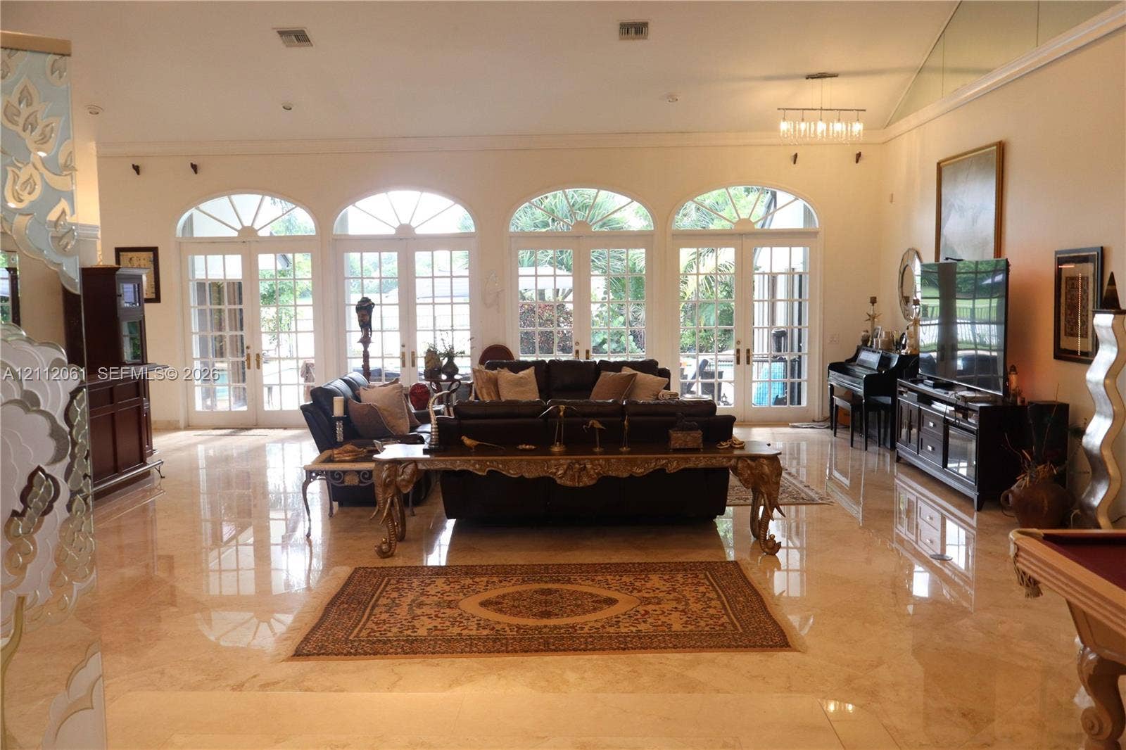 17191 SW Shaddock Lane, Boca Raton, FL 33487 Polished stone flooring, high ceilings, and four sets of arched French glass doors