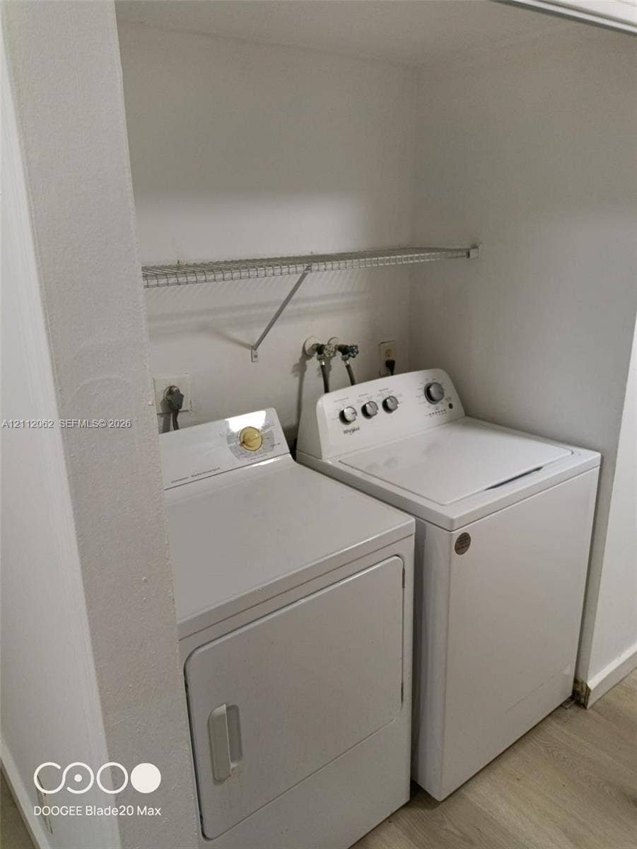300112 NW 68th Street, #9G, Fort Lauderdale, Fort Lauderdale, FL 33309 Laundry alcove featuring wood-finish flooring and a wire shelving unit