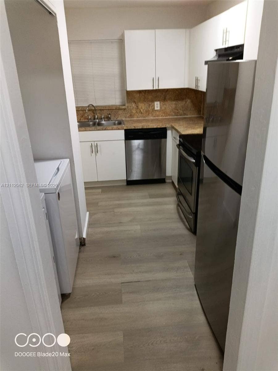 300112 NW 68th Street, #9G, Fort Lauderdale, Fort Lauderdale, FL 33309 Kitchen featuring white cabinetry, wood-finish flooring, stainless steel appliances, and a dual-basin sink with a countertop