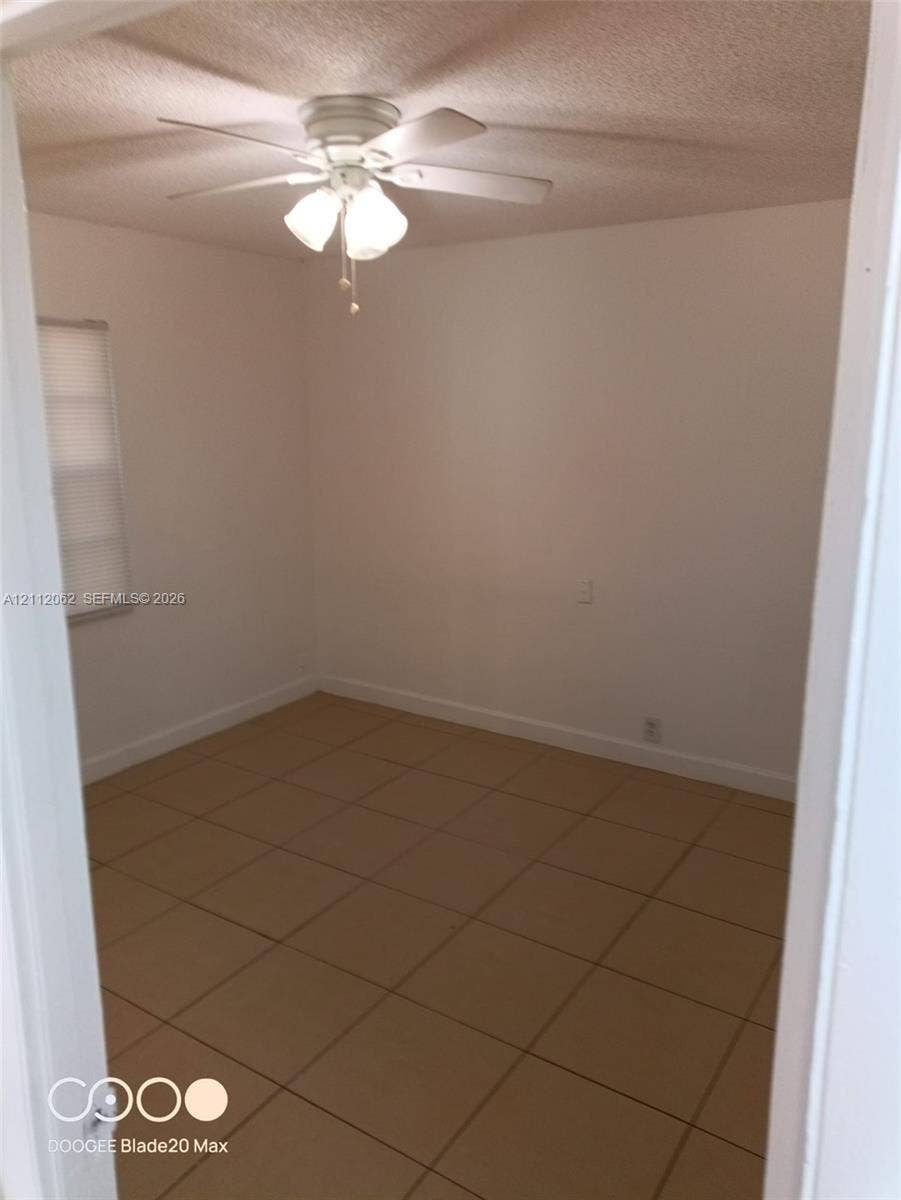 300112 NW 68th Street, #9G, Fort Lauderdale, Fort Lauderdale, FL 33309 Square ceramic tile flooring, neutral wall finish, and a ceiling-mounted fan with integrated lighting