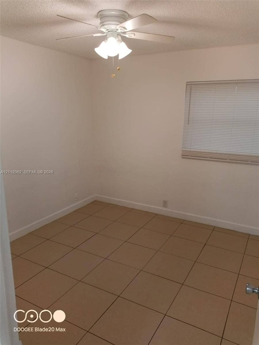 300112 NW 68th Street, #9G, Fort Lauderdale, Fort Lauderdale, FL 33309 Room featuring ceramic tile flooring, a multi-light ceiling fan, and window blinds