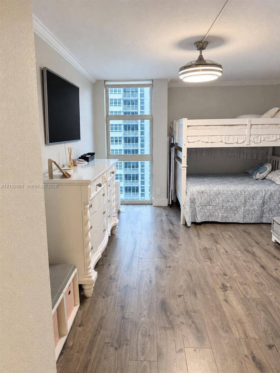 1360 S Ocean Boulevard, #2503, Pompano Beach, Pompano Beach, FL 33062 Floor-to-ceiling window, wood-finish flooring, crown molding, and brushed nickel ceiling fan with integrated lighting