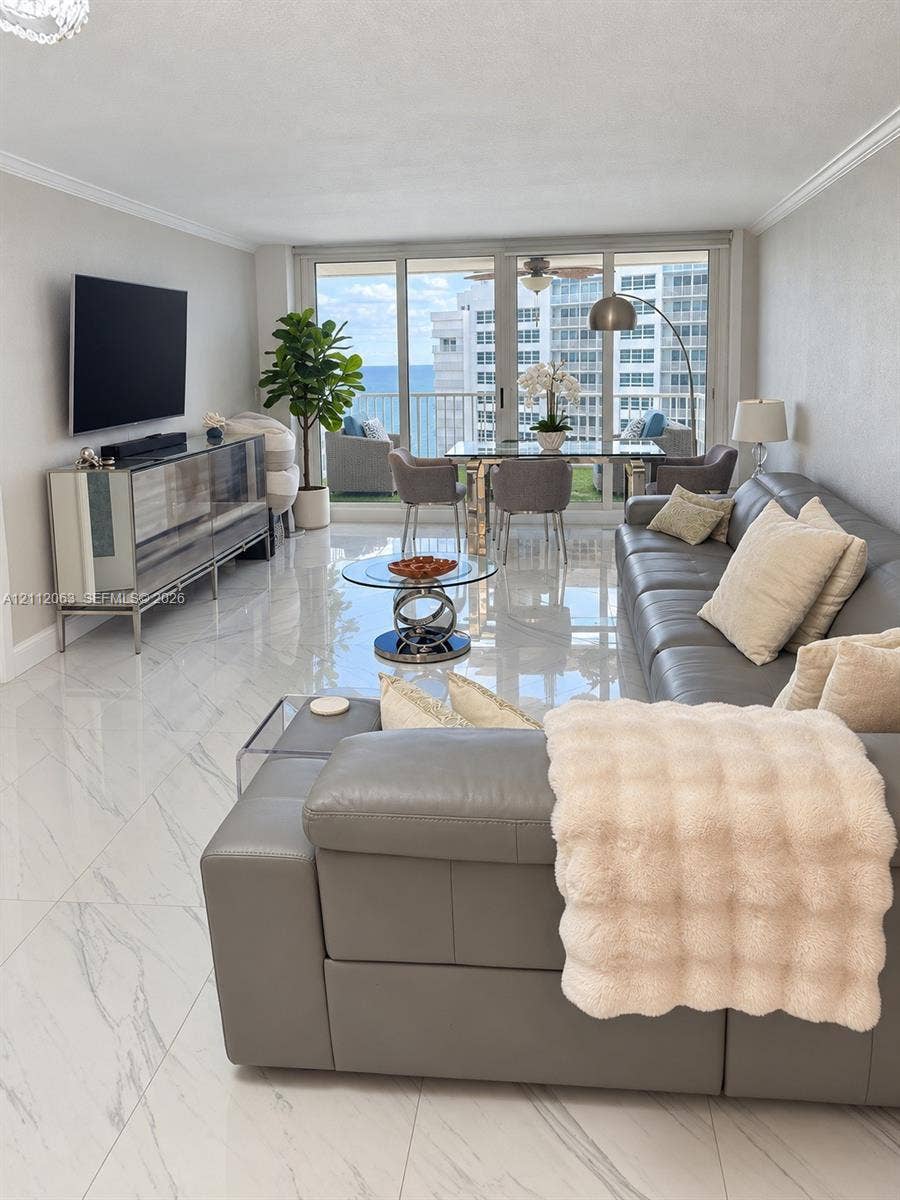 1360 S Ocean Boulevard, #2503, Pompano Beach, Pompano Beach, FL 33062 Open-concept living space featuring high-gloss large-format floor tiling, crown molding, floor-to-ceiling glass sliding doors, and a private balcony