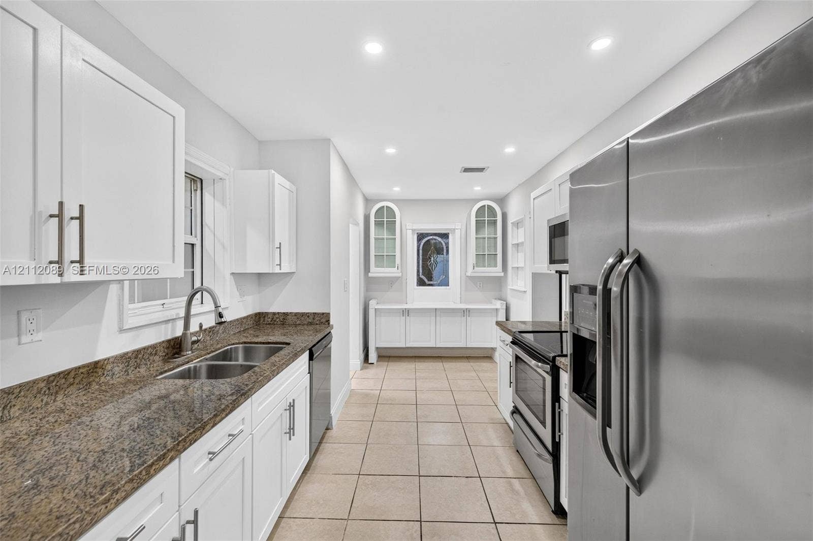 2017 NE 29th Court, Fort Lauderdale, FL 33306 Kitchen featuring white cabinetry, stone countertops, double-basin stainless steel sink, recessed lighting, and tile flooring
