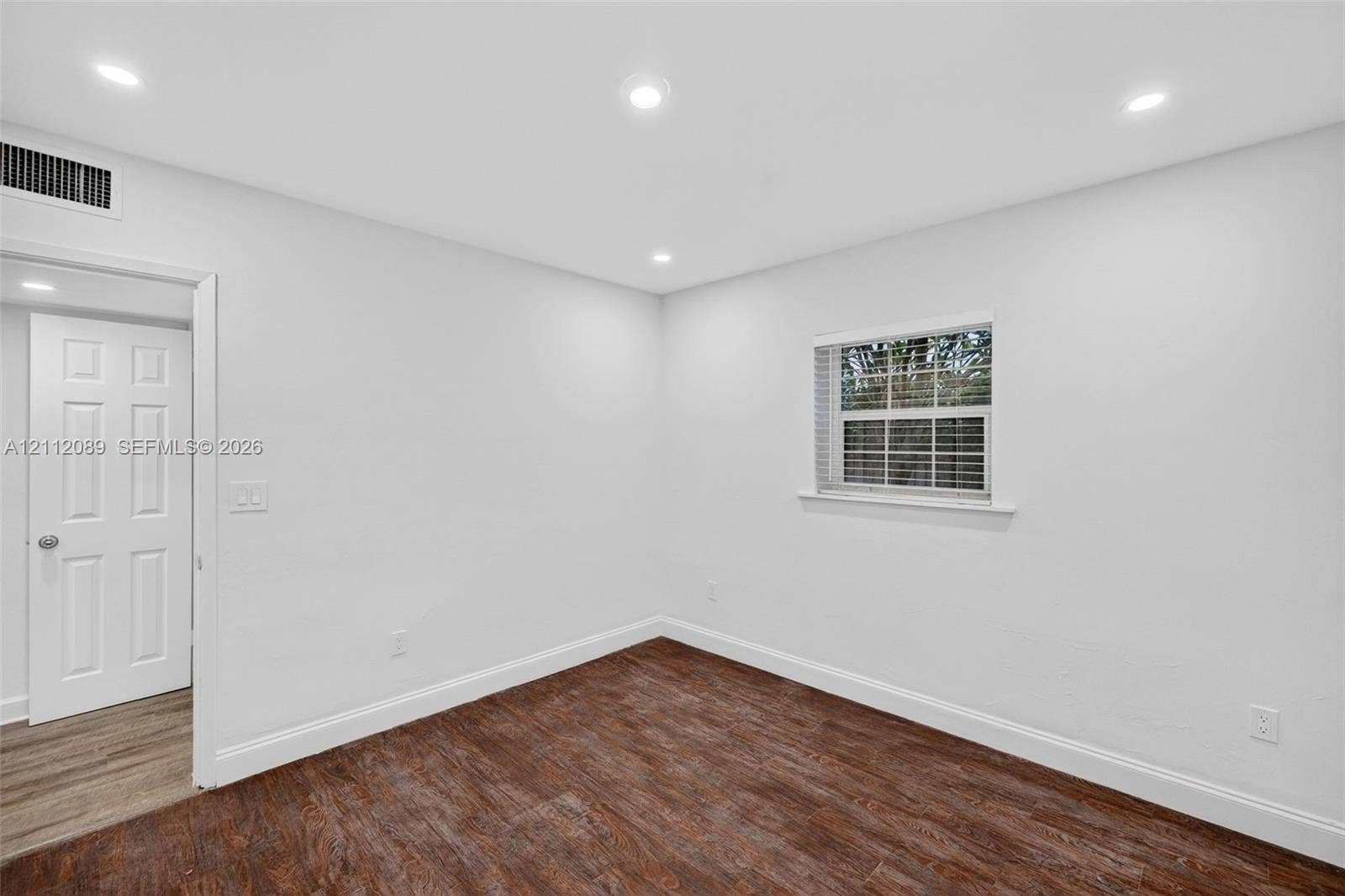 2017 NE 29th Court, Fort Lauderdale, FL 33306 Neutral interior space featuring wood-finish flooring, recessed lighting, a multi-pane window with blinds, and a six-panel door