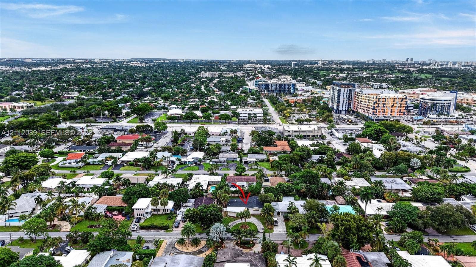 2017 NE 29th Court, Fort Lauderdale, FL 33306 Aerial perspective featuring a single-story residence with a pitched roof, circular driveway, mature landscaping, and an enclosed backyard