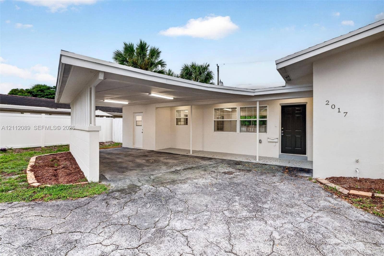 2017 NE 29th Court, Fort Lauderdale, FL 33306 Exterior featuring a covered carport, recessed lighting, solid entry door, and perimeter vinyl fencing