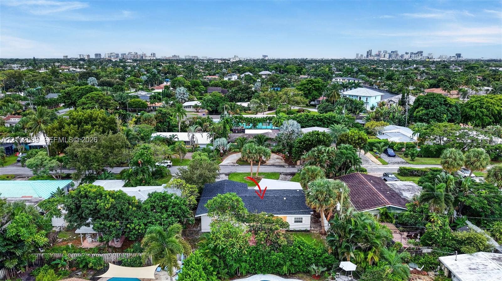 2017 NE 29th Court, Fort Lauderdale, FL 33306 Aerial perspective of property featuring a dark-toned shingle roof, mature tropical vegetation, and extensive surrounding tree canopy