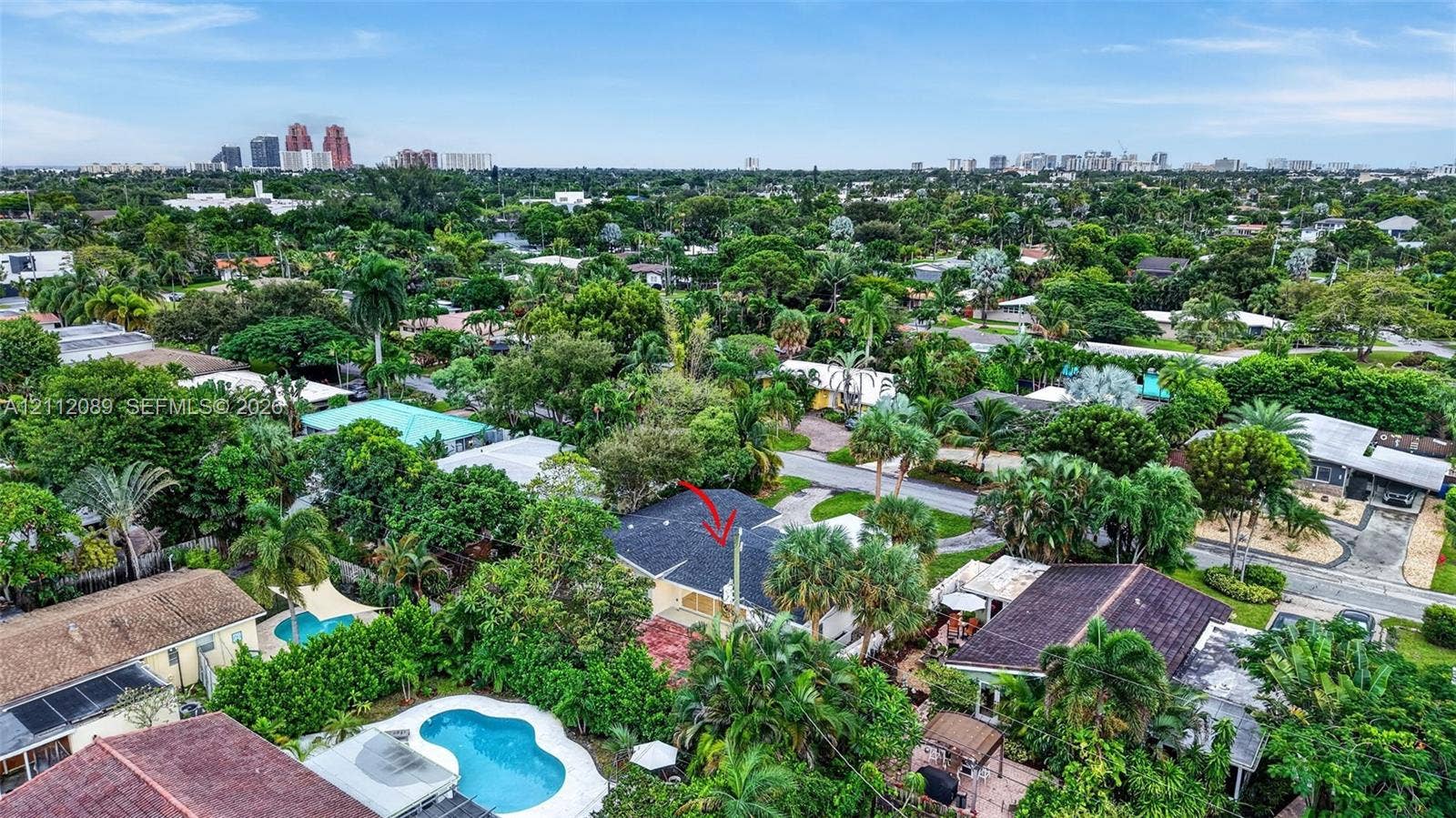 2017 NE 29th Court, Fort Lauderdale, FL 33306 Aerial perspective of property featuring a shingled roof, mature tropical landscaping, and a surrounding neighborhood canopy