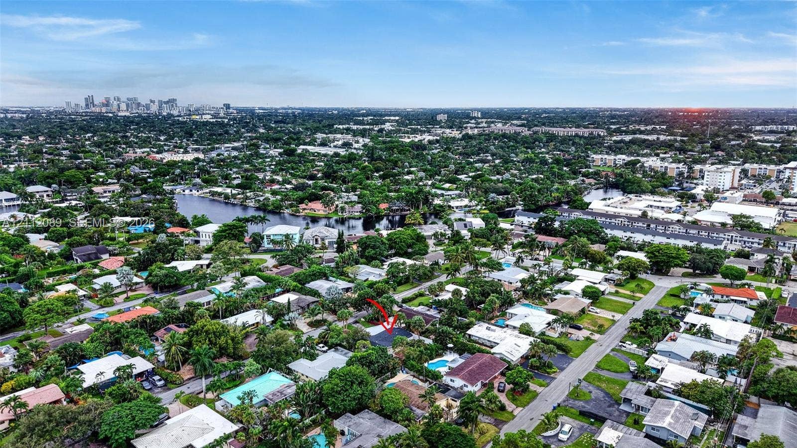 2017 NE 29th Court, Fort Lauderdale, FL 33306 Aerial perspective featuring a residential lot with mature trees and a city skyline backdrop